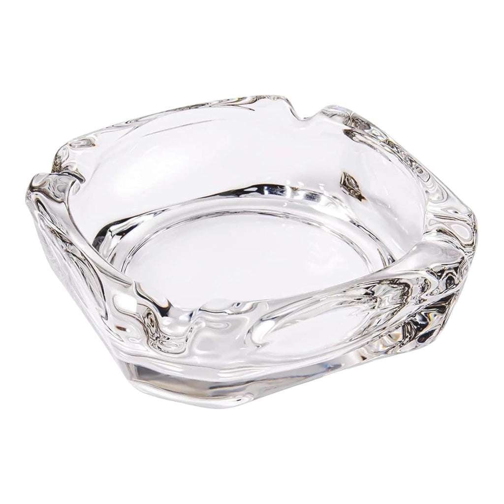 Elegant crystal glass ashtray with four cigar slots on a modern wooden table.