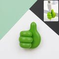 Green hand-shaped wall clip holder holding cables and keys securely