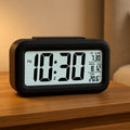 Digital LCD alarm clock with backlight showing time and temperature