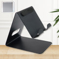 Universal metal mobile and tablet stand holder placed on desk for hands-free use