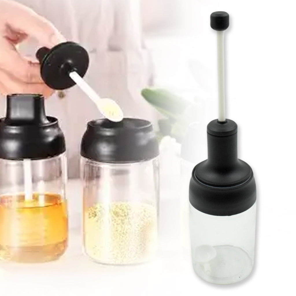 The transparent glass body of the spice container, showing its contents clearly.