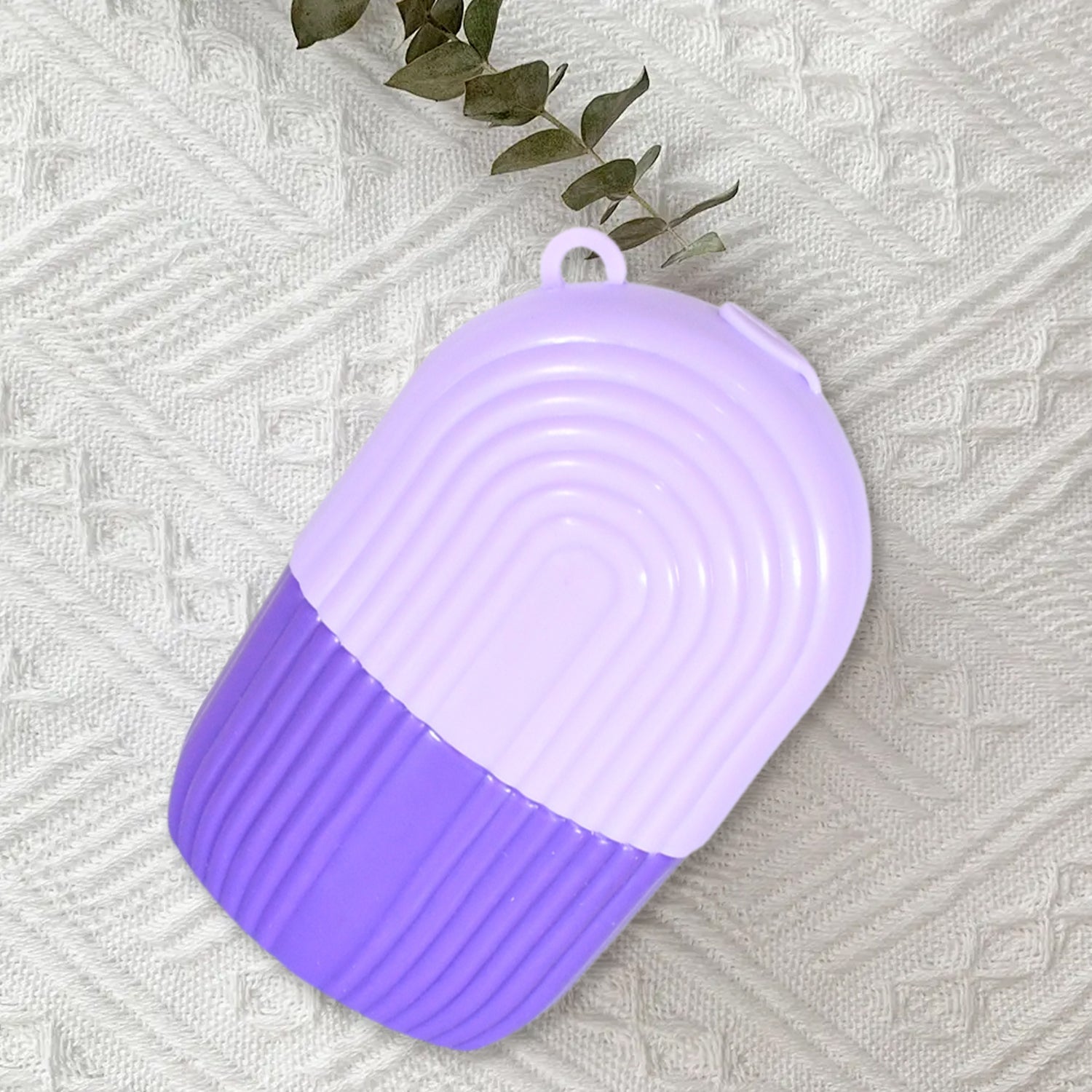 GlowForm purple ice roller placed next to various facial skincare products.