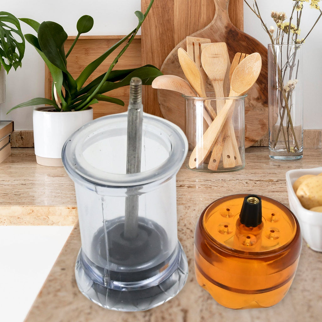 Transparent plastic salt and pepper grinder on a white surface.
