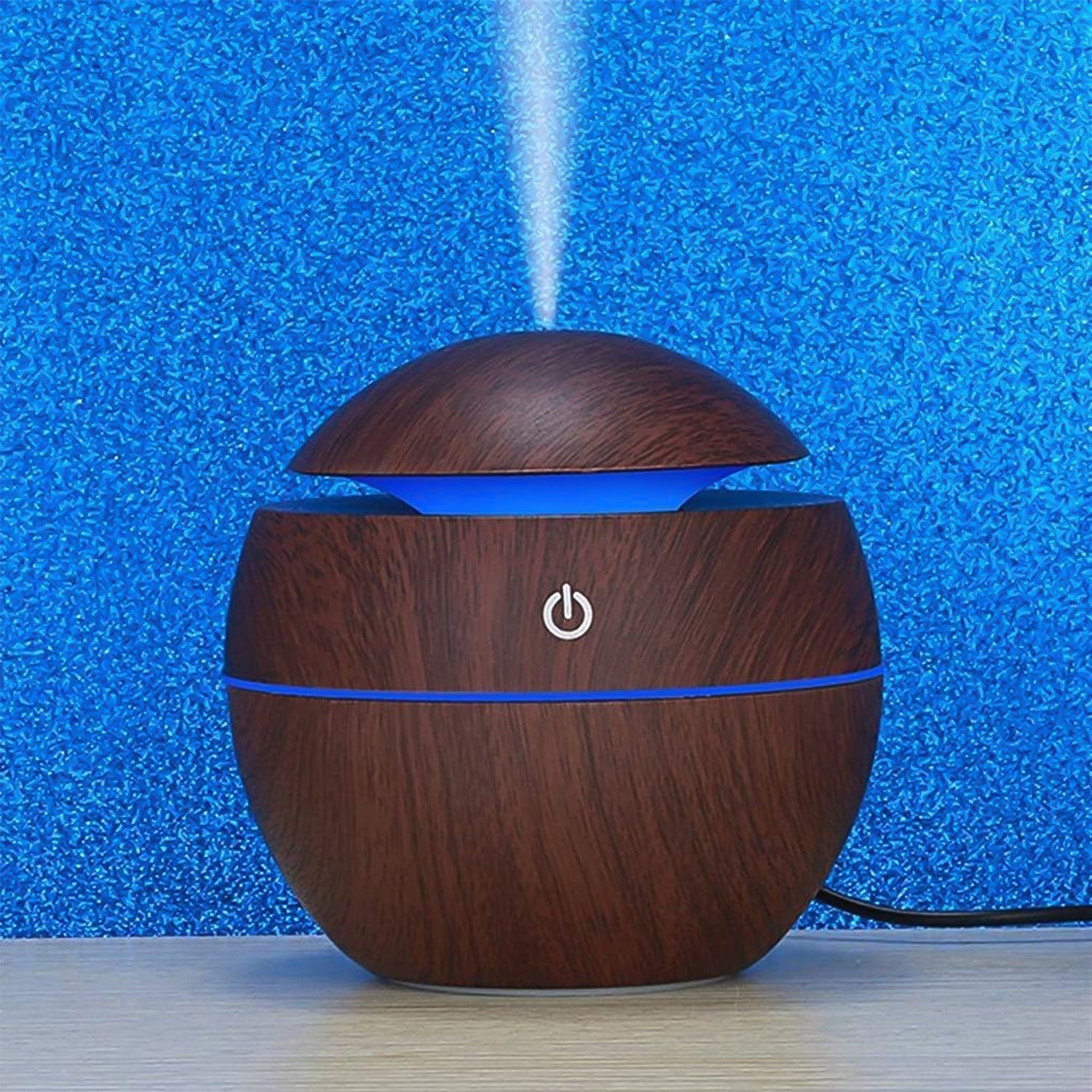 Compact USB desktop humidifier with multi-color LED lights on a clean surface.