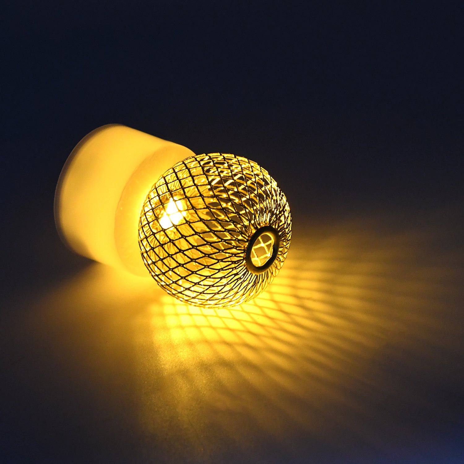 Flameless LED candles arranged with other decorative items on a shelf, creating a cozy ambiance.