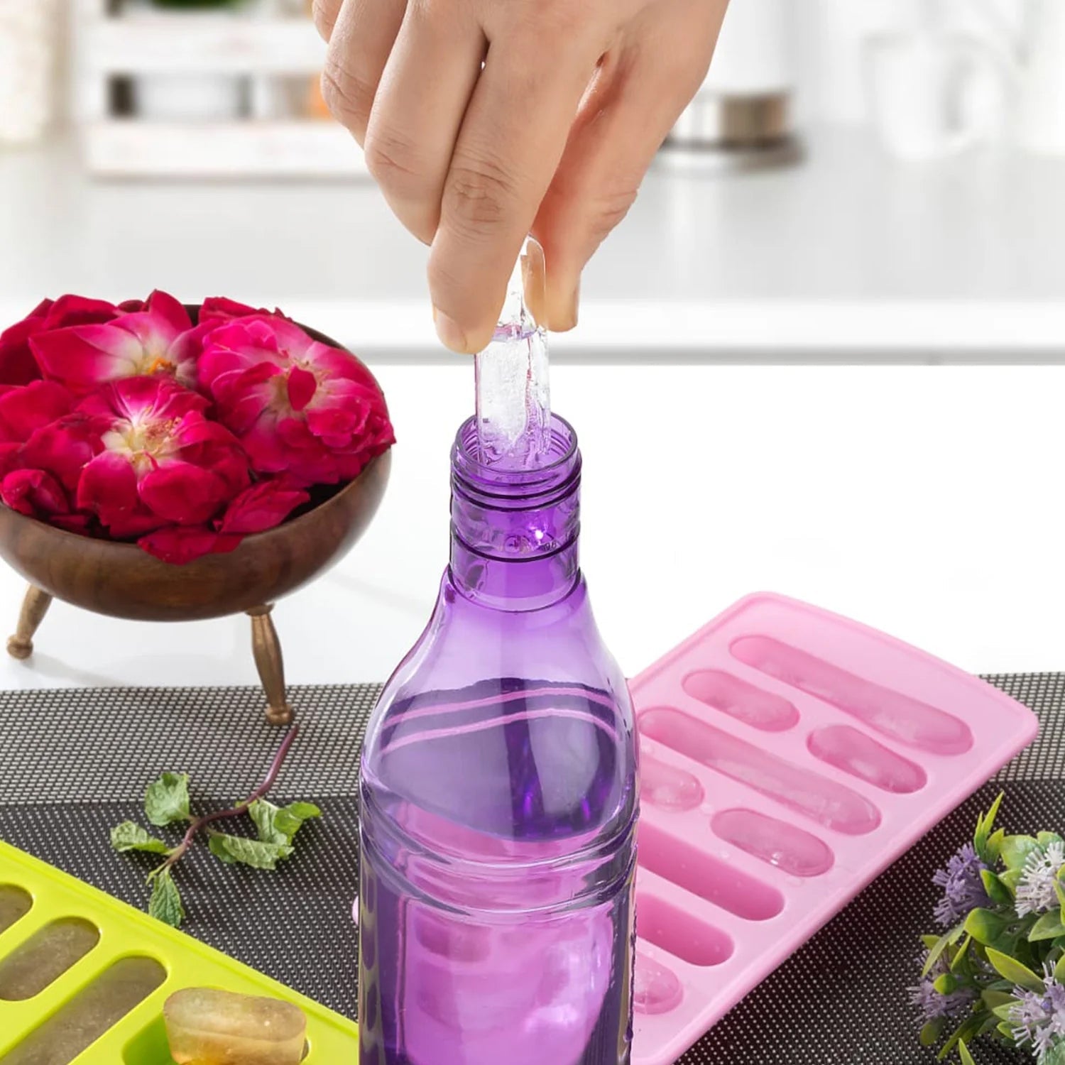 Several clear ice cubes from the ice tray chilling a refreshing drink in a glass.
