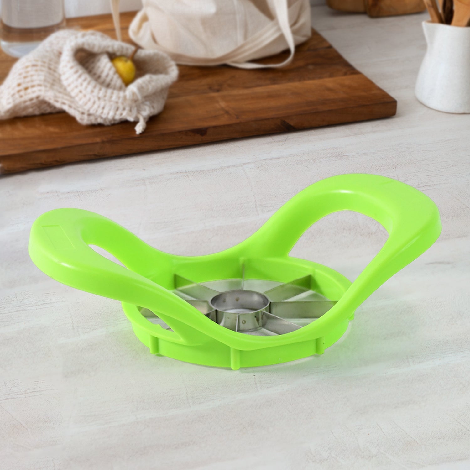 Hand demonstrating how to use the apple cutter to core and slice fruit.