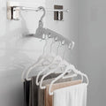 Foldable clothes hanger with 5 holes, shown extended for use in a closet.