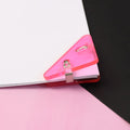 Close-up of durable triangle paper clip securing paper corner