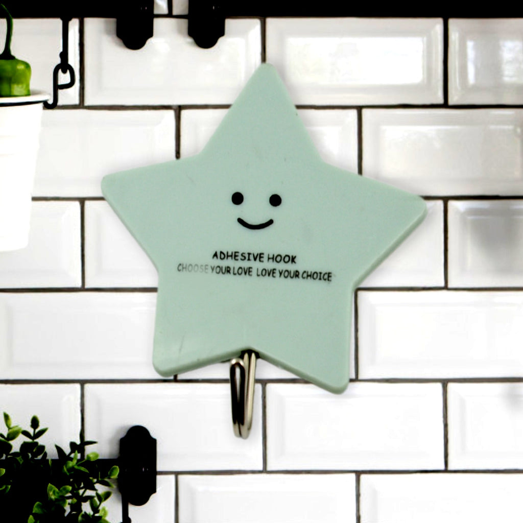 A set of strong self-adhesive hooks displayed neatly on a tiled kitchen wall, ready for use.