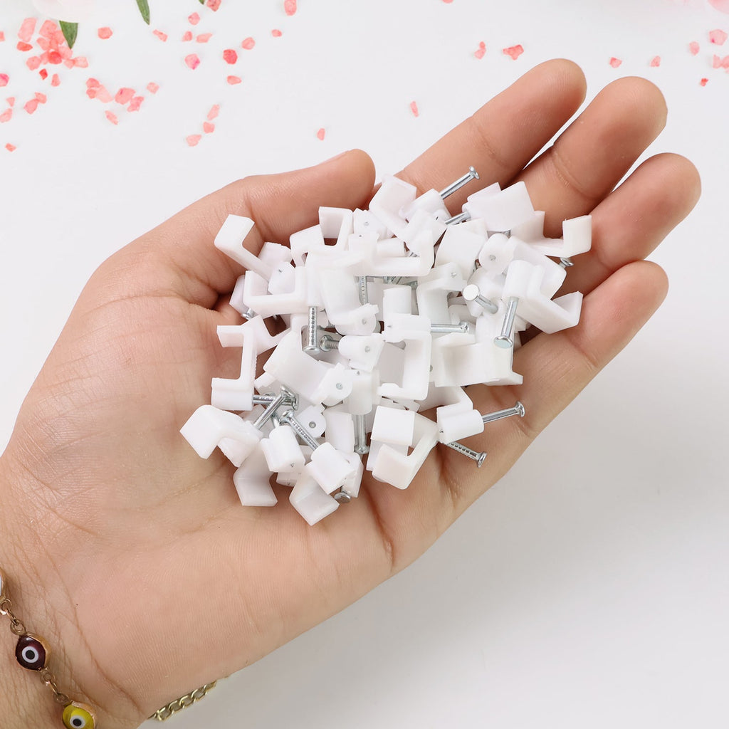 Nail cable clips mounted on wooden surface holding cables securely