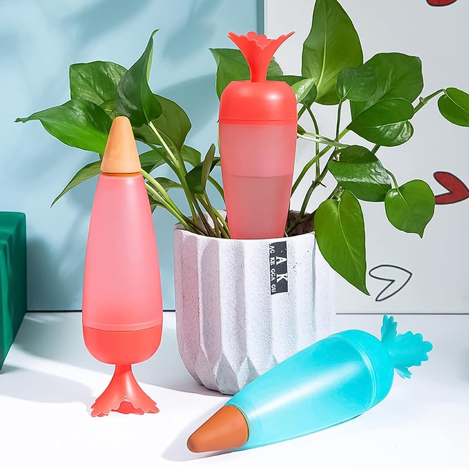 Group of colorful carrot-design automatic plant watering globes ready for use.
