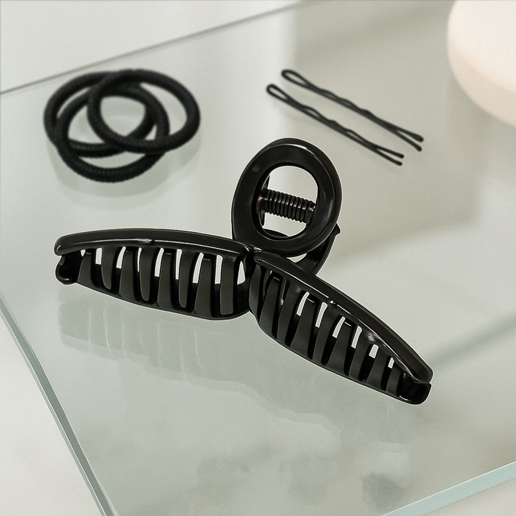 Back view of woman wearing hair claw clip holding elegant updo securely