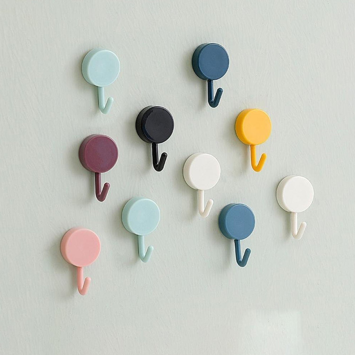 Pack of 10 transparent self-adhesive wall hooks on a white surface.