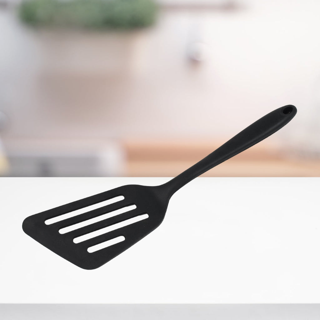 Heat-resistant silicone kitchen turner in action on a pan.