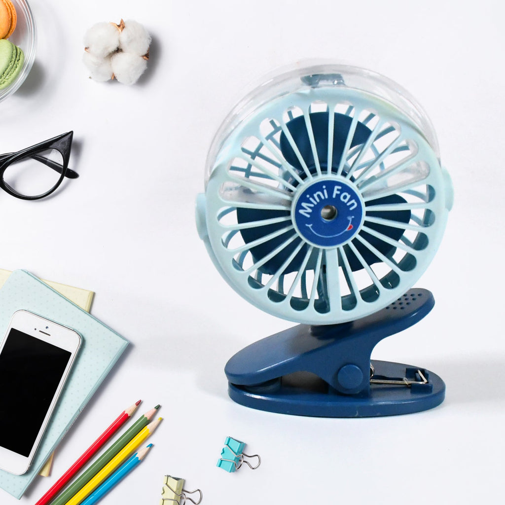 A person using the  rechargeable mini fan for personal cooling on a desk.