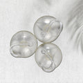 Two transparent suction hooks with strong hold on a bathroom tile wall.