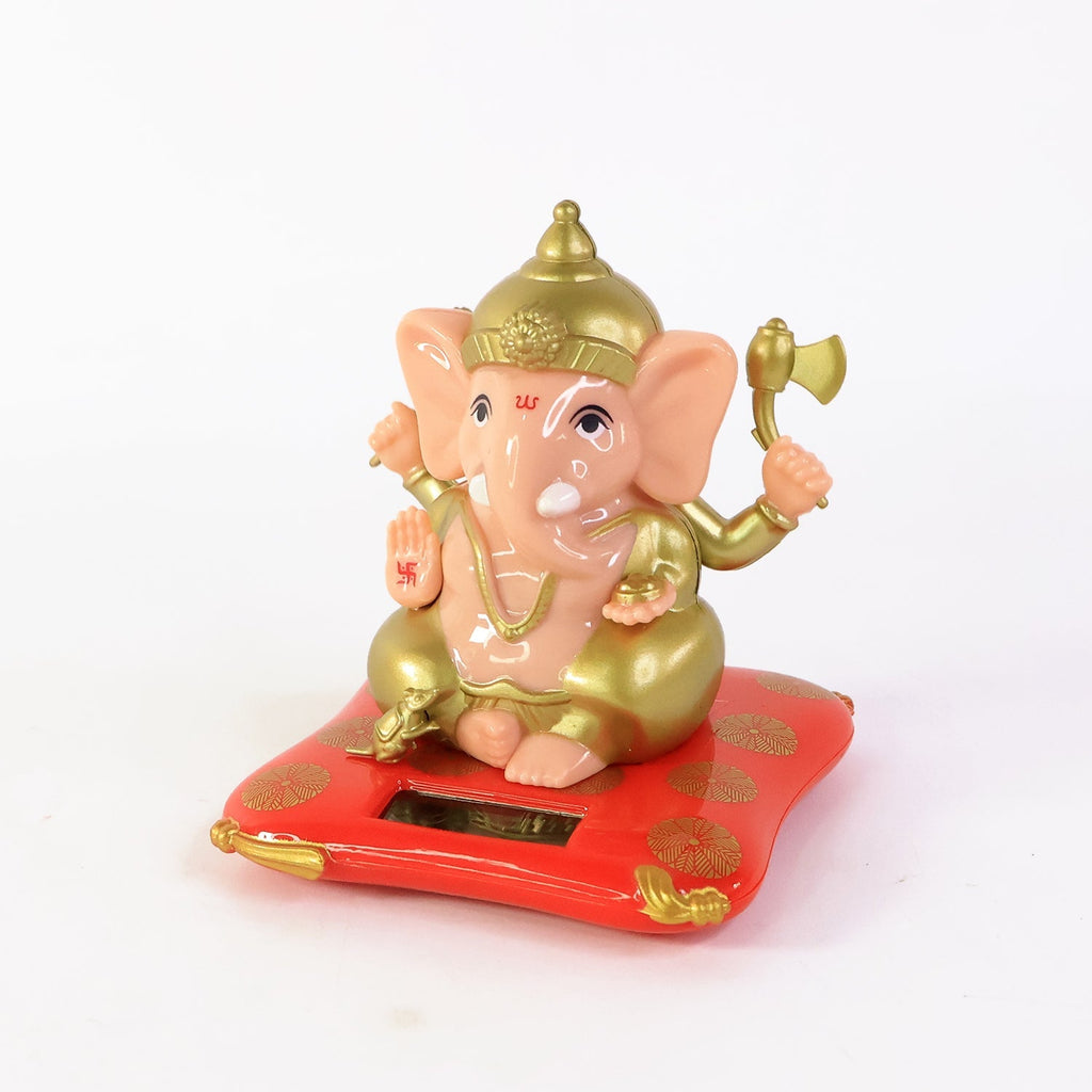 Lord Ganesh Idol glowing warmly on solar-powered red base in serene setting