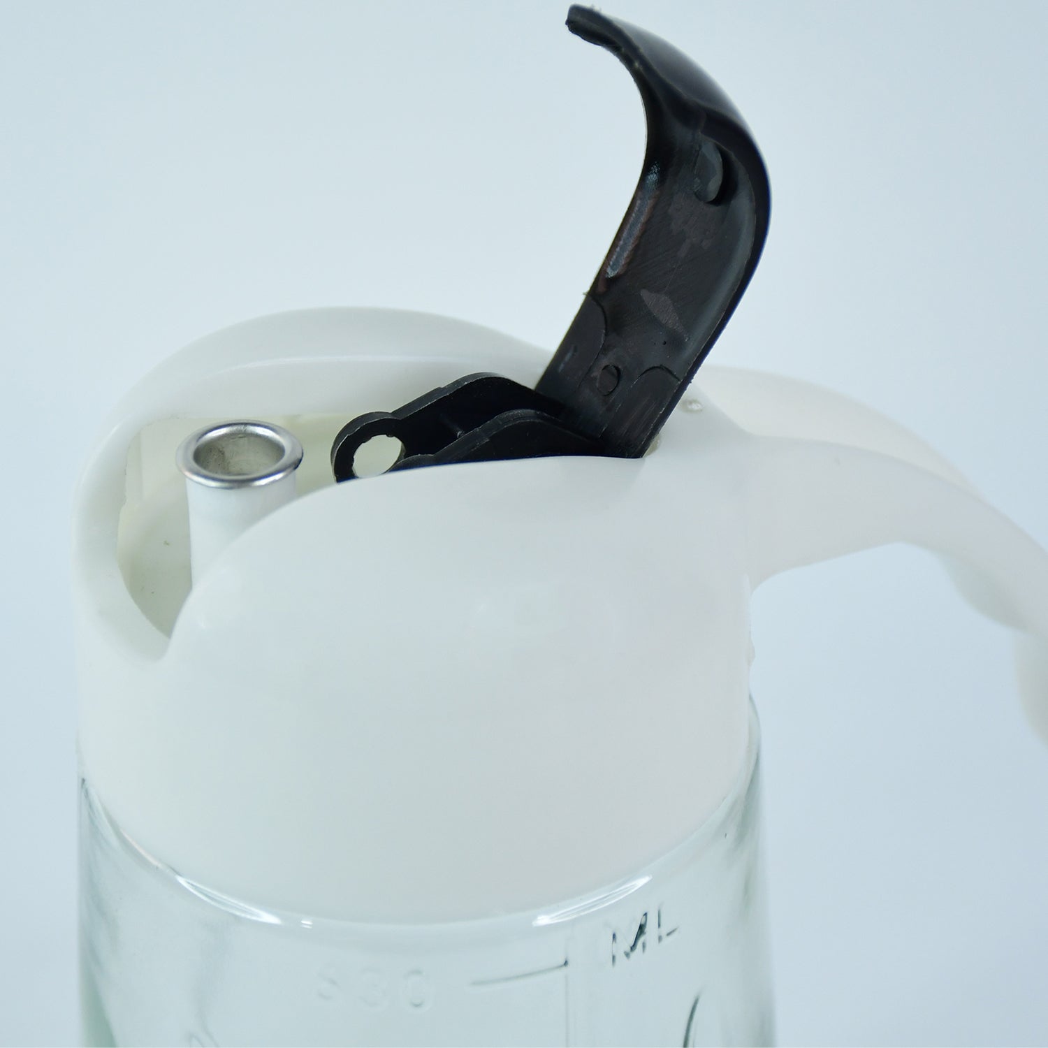 Pouring olive oil using glass oil bottle dispenser in kitchen setting