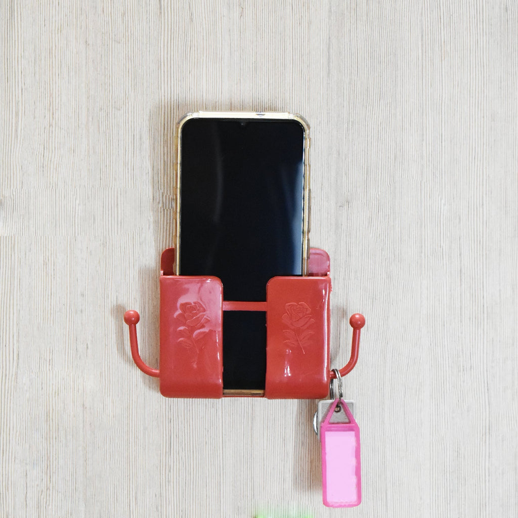 Wall mounted remote holder in use, decluttering a bedside table or desk area.