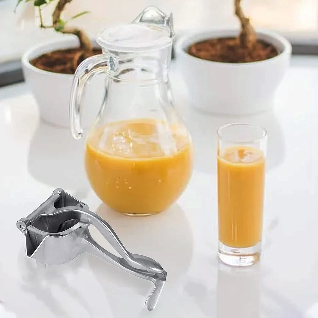 Fresh orange half being pressed in the efficient manual fruit juicer.