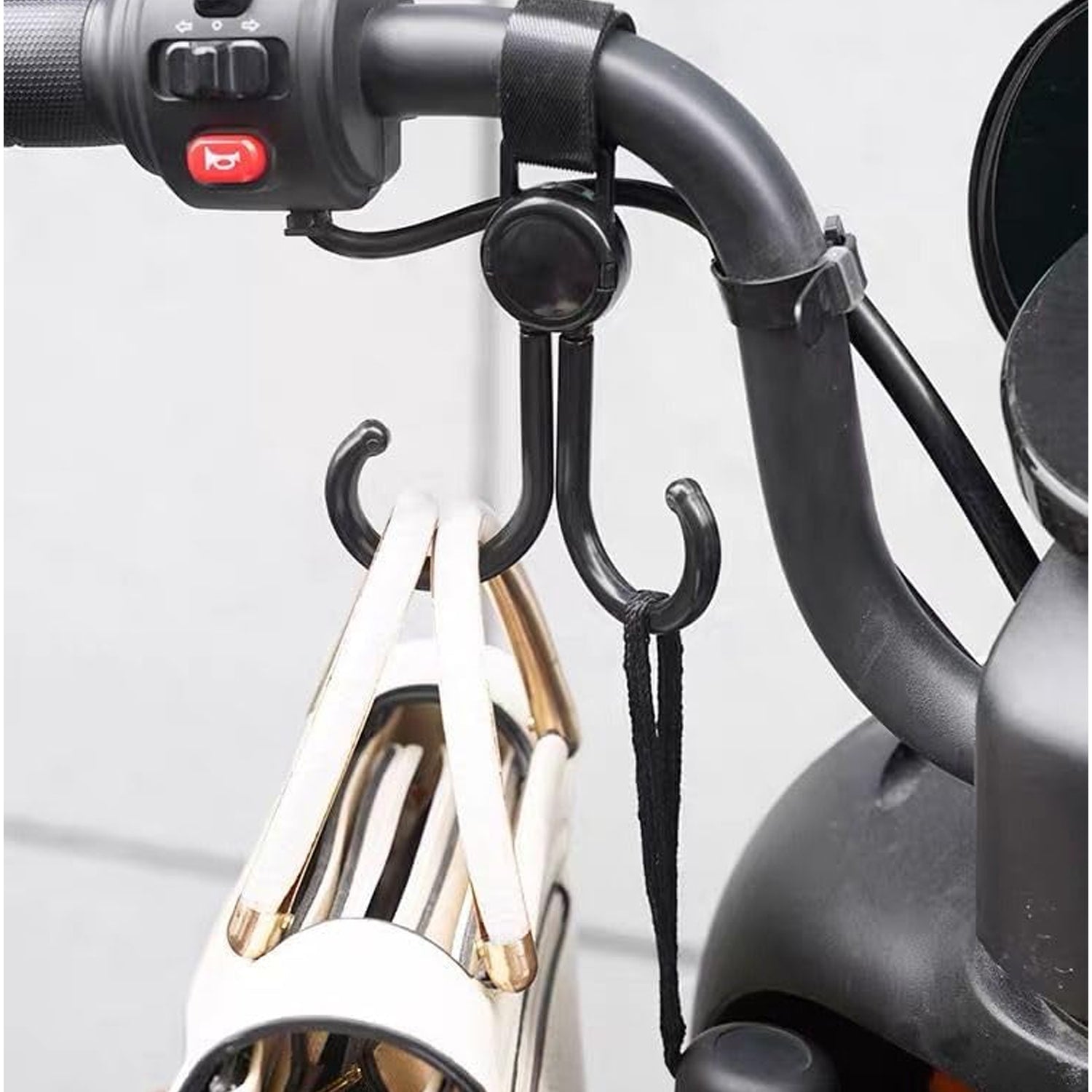 Multi-purpose stroller hook holding shopping bags and a purse on a pram.
