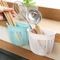 White hanging plastic storage basket mounted on a tiled wall, holding toiletries and soap.