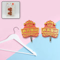 A pair of white self-adhesive hooks displayed on a clean wall.