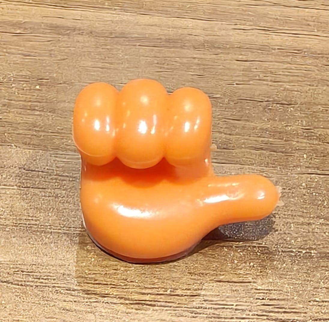 Orange silicone hand-shaped clip holder fixed to wall for cables
