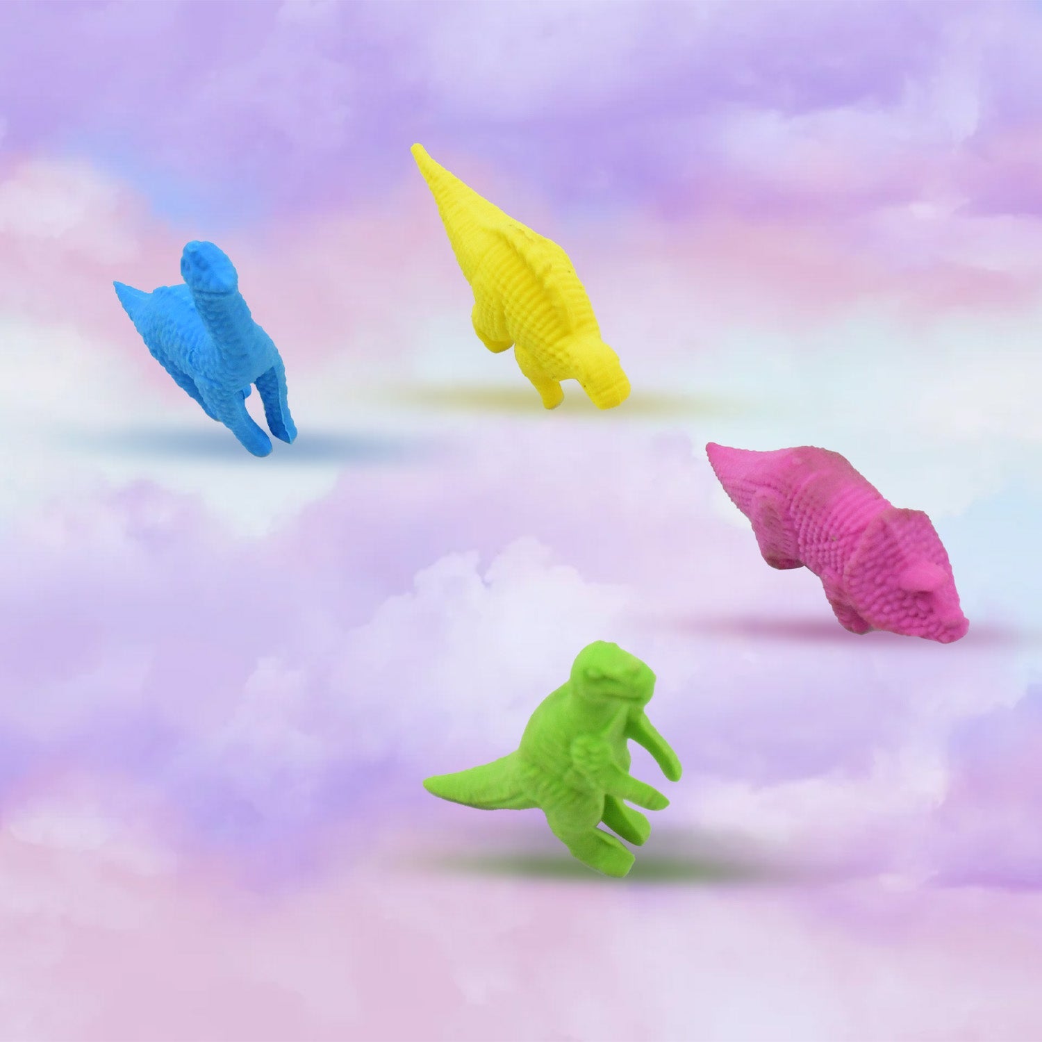 Three cute dinosaur erasers in red, blue, and green, arranged neatly on a surface.
