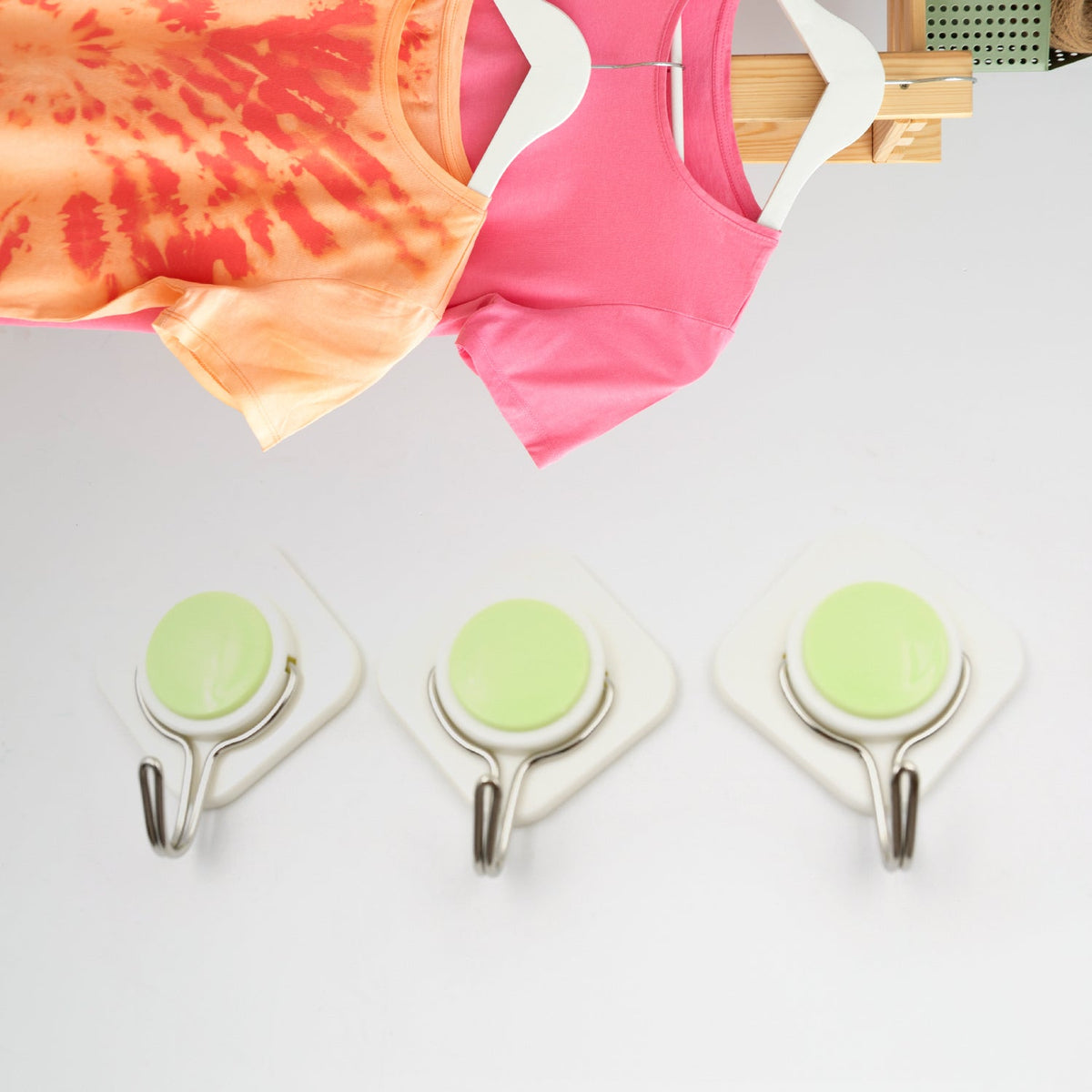 Heavy-duty wall hooks securely holding kitchen utensils on a tiled wall.