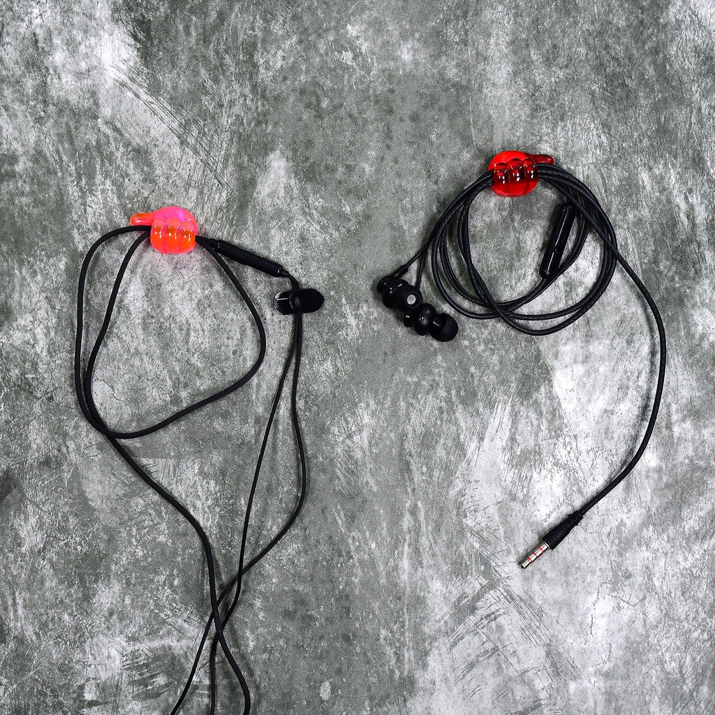 A set of multi-functional hand shape wall clips holding various items like cables and keys.