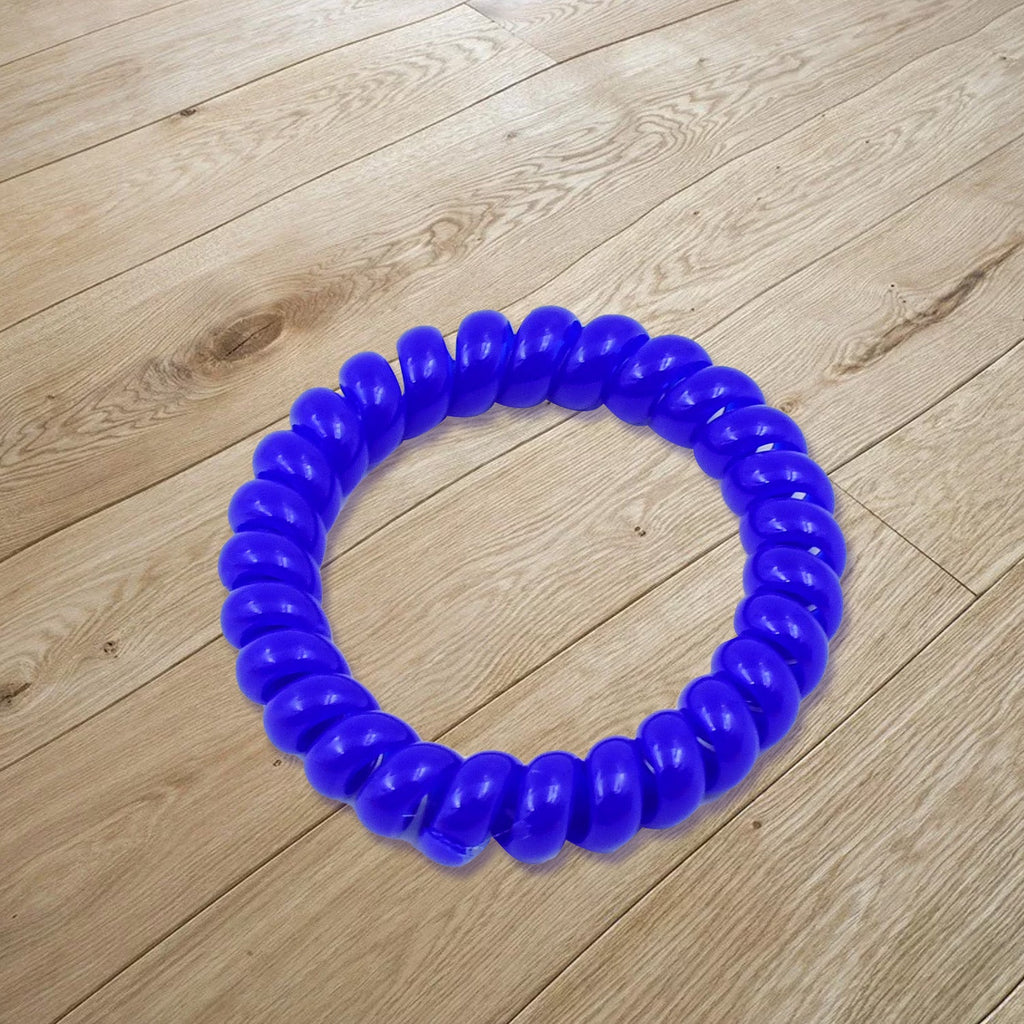Close-up of a single purple telephone wire hair band showing its spiral design.