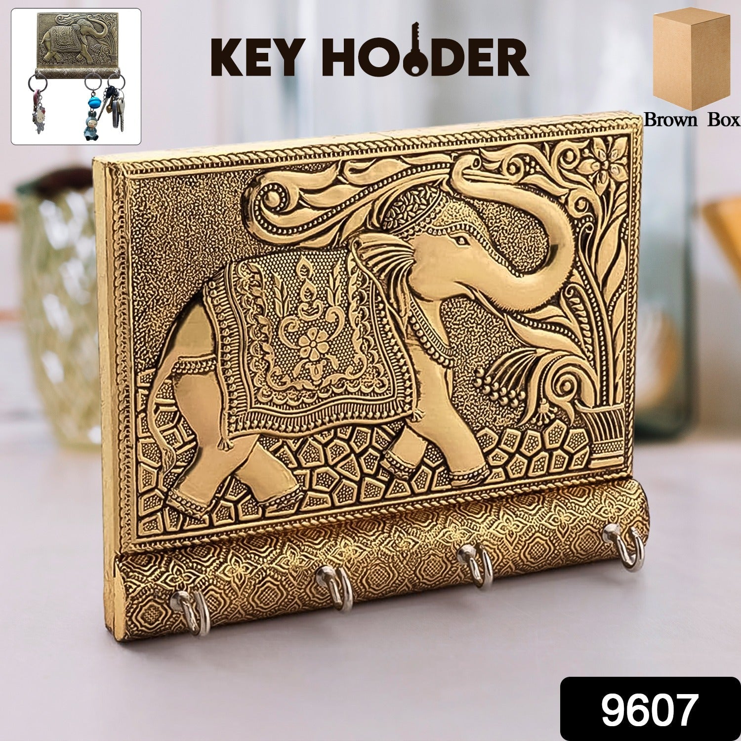 Close-up of the polished gold elephant head and hooks on the wooden key holder.