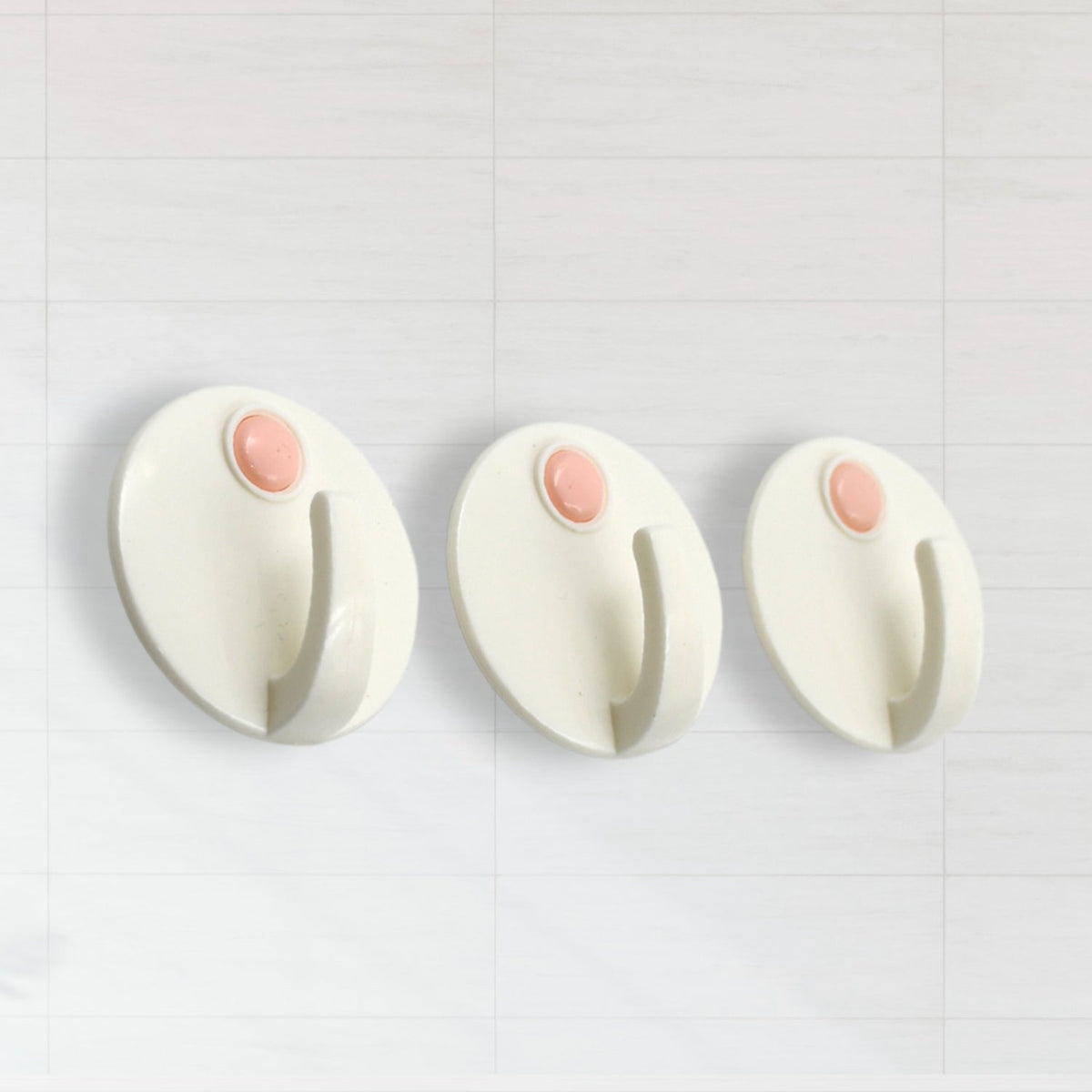A stylish self-adhesive hook holding a bath towel in a contemporary bathroom setting.
