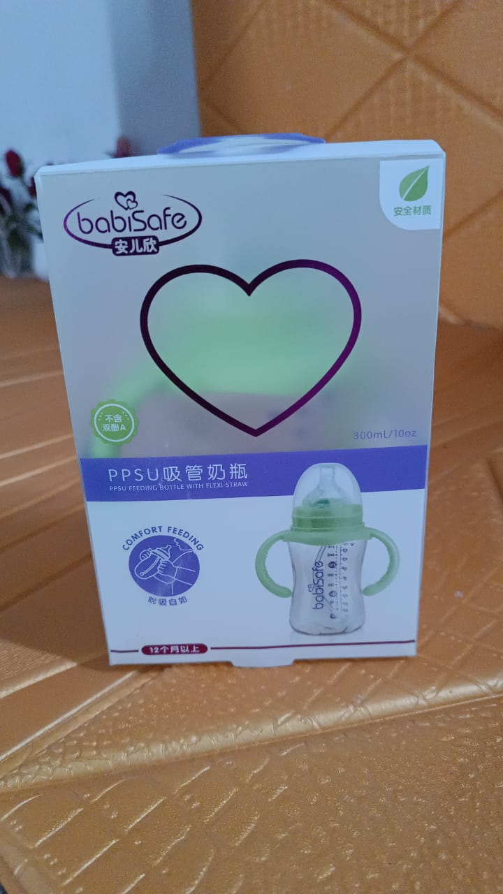 A child holding the Feedora plastic baby feeding bottle with handles, ensuring a firm grip.