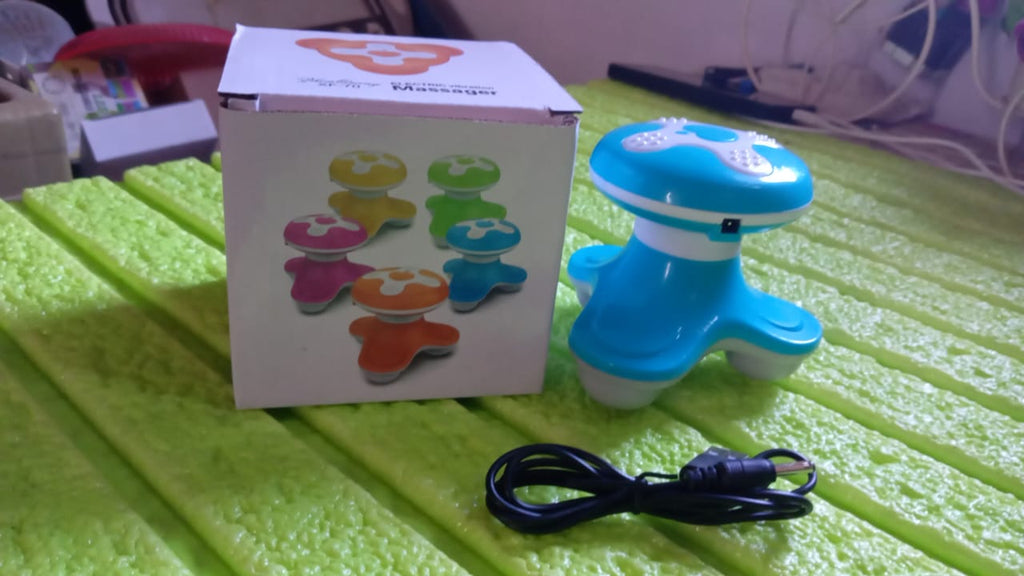 The portable massager placed on a travel bag, highlighting its travel-friendly size.