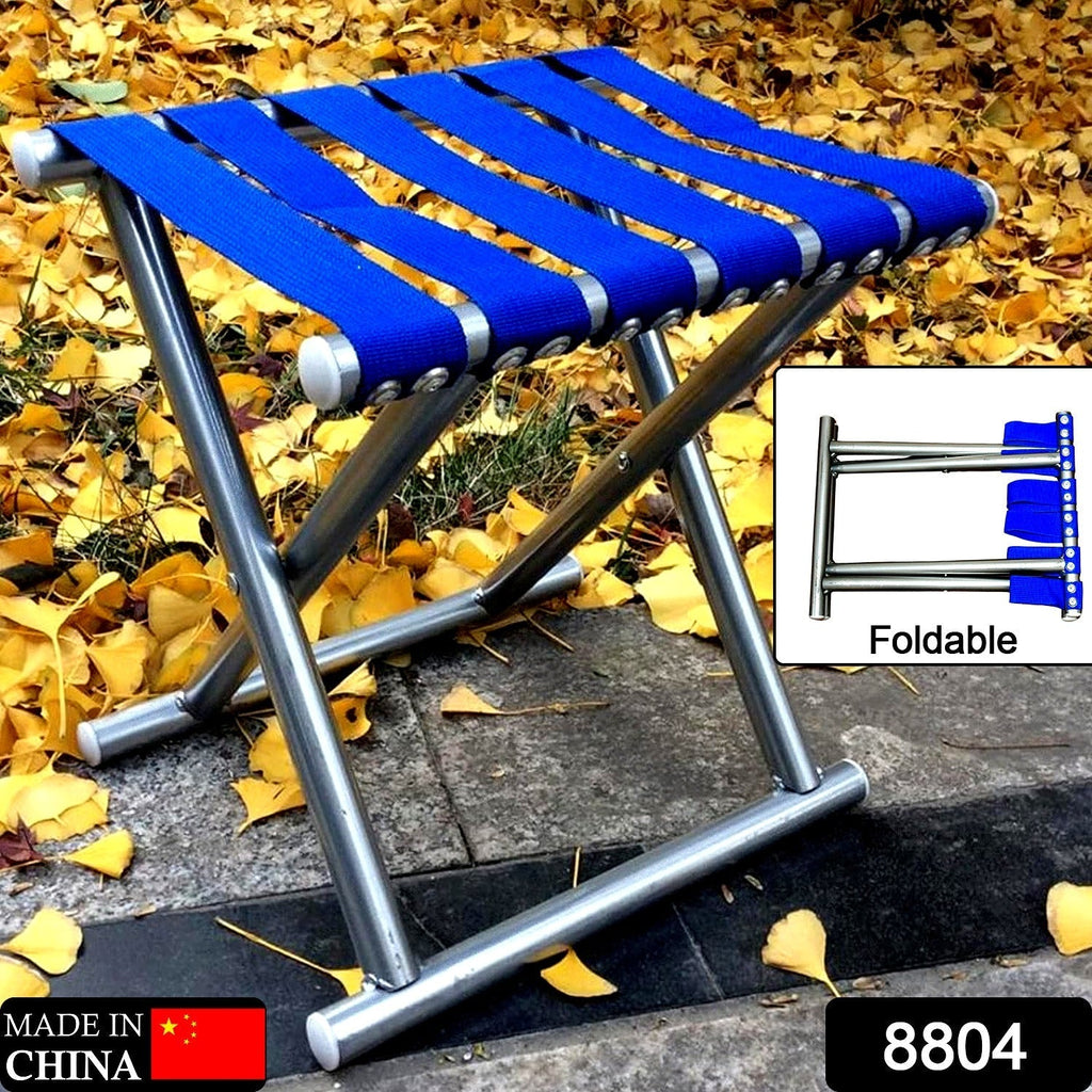 The portable folding travel stool neatly collapsed, highlighting its space-saving design for easy transport.