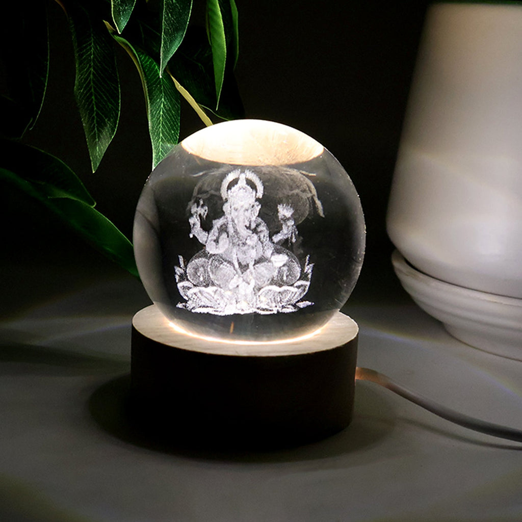 Detailed view of the illuminated 3D Ganpati idol inside the crystal ball, showing its radiant effect.