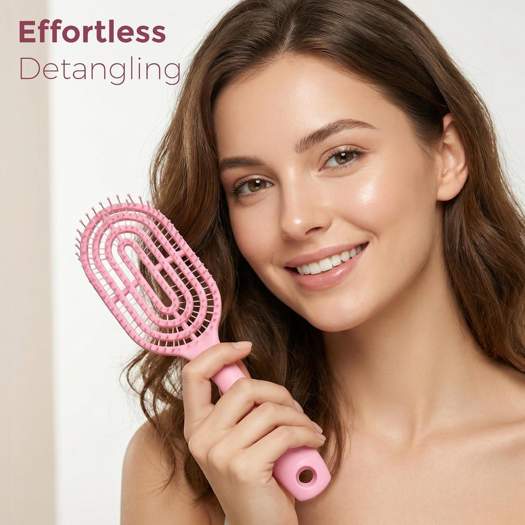 Person holding pink curved vented detangling hair brush while styling