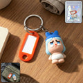Cartoon baby character keychain with label tag holder attached to a key ring.