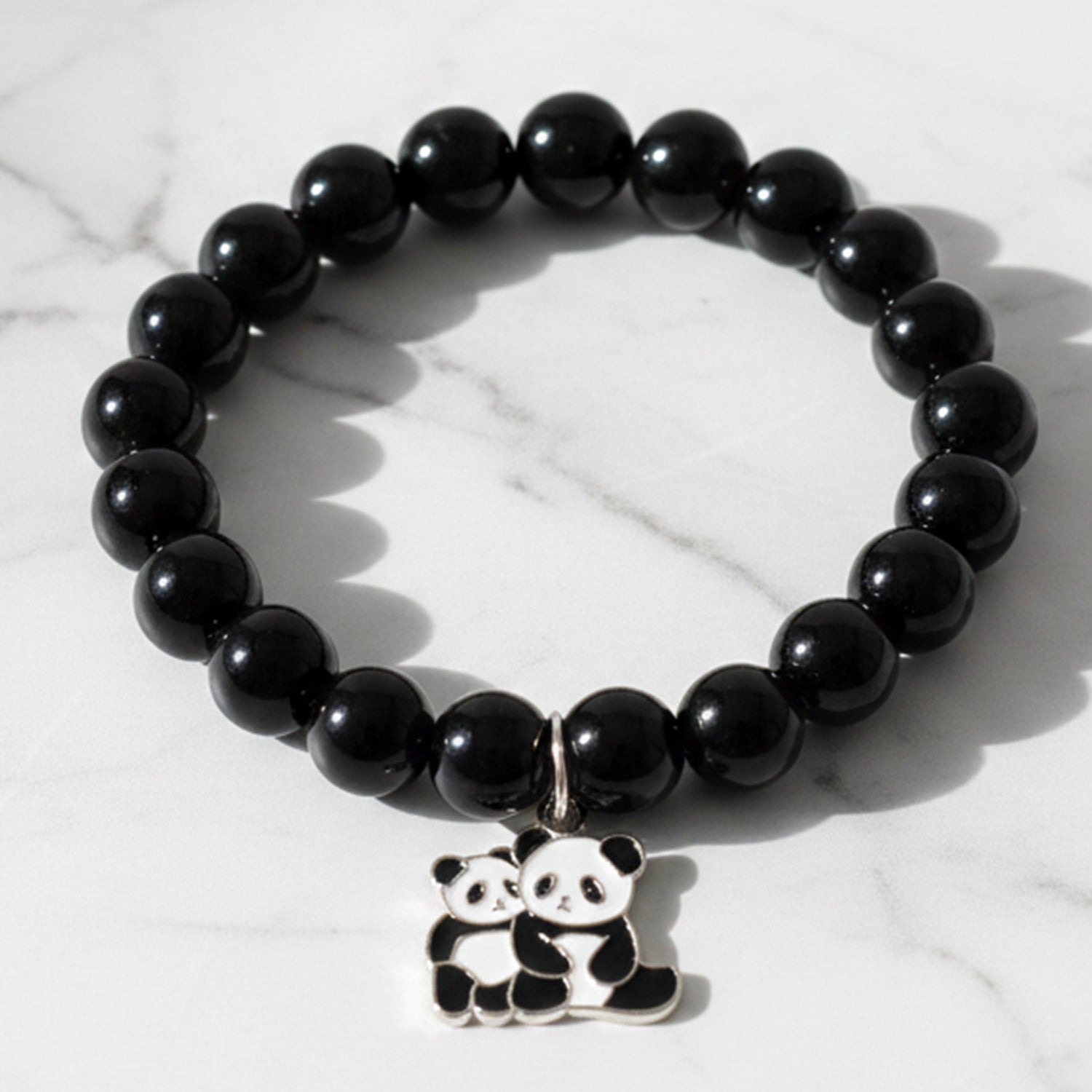 Black beaded stretch bracelet with an adorable panda charm on white background.
