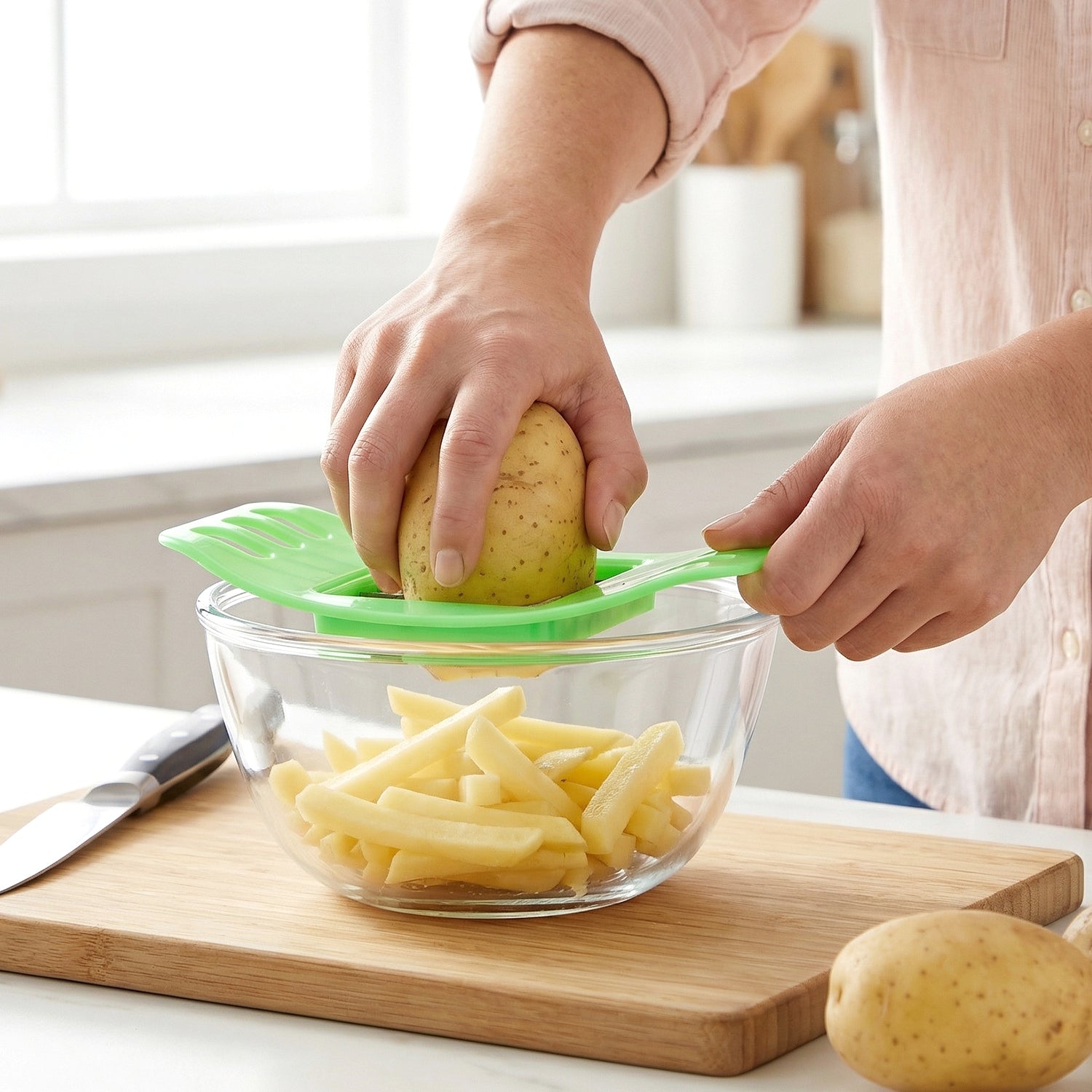 Freshly cut potato fries arranged next to the Indo Glow potato fries cutter.