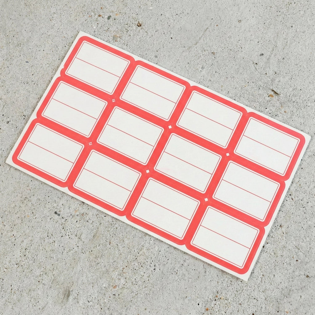 Close-up view of red and white rectangular self-adhesive label stickers