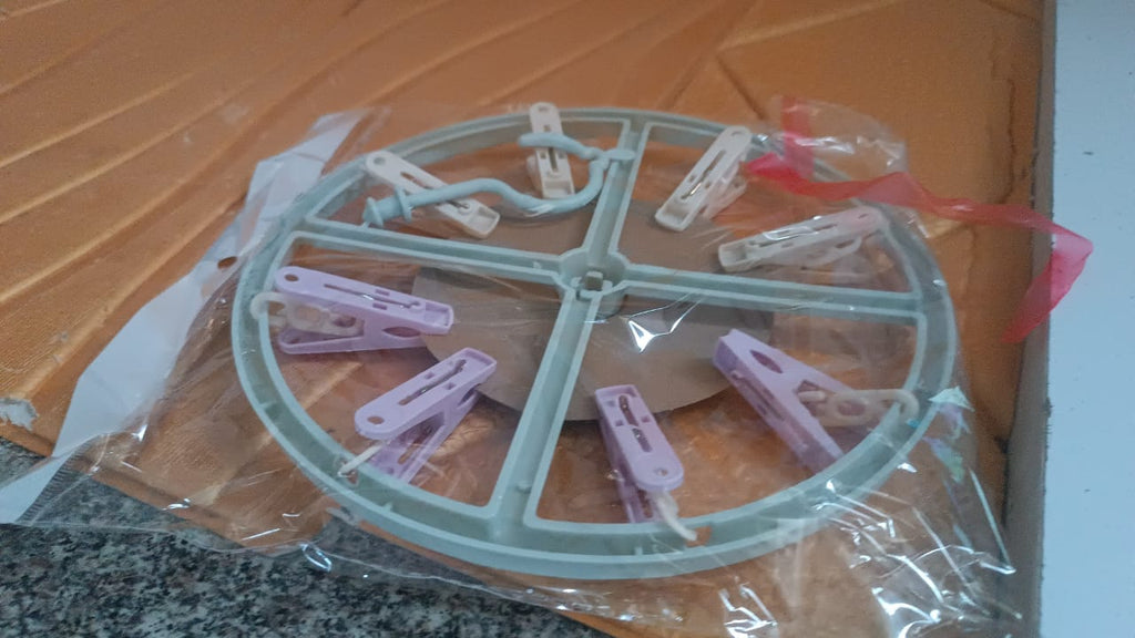 Laundry drying rack with clothespin clips hanging near window