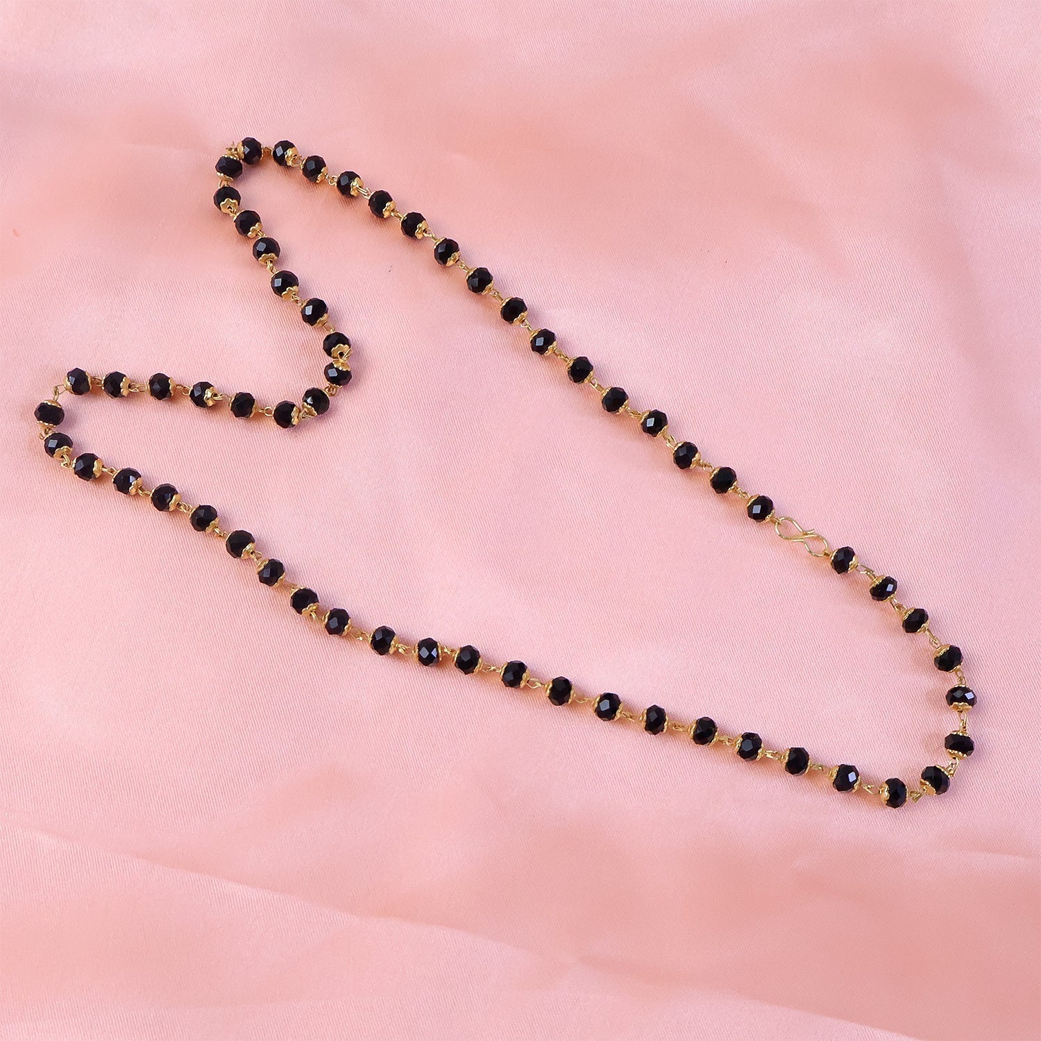 Close-up of black bead mangalsutra necklace with golden bead detailing