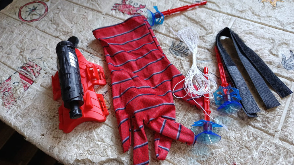 An action shot shows Web Shooter Toy projectiles successfully sticking to a wall.