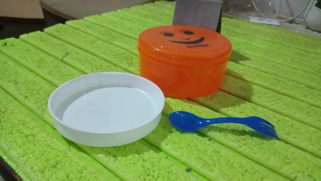 Assorted colourful plastic lunch boxes displayed together.