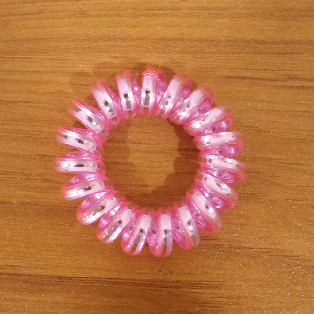 Group of mixed color spiral hair ties on a white background